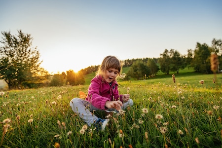 Kid in the nature playing with dandelions - Allergy Drops