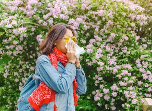 Girl sneezing outside because of allergies on pollen - Sinusitis