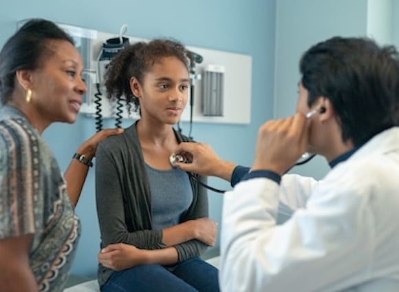 Doctor diagnosing asthma on a girl