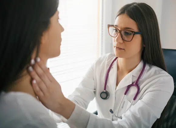 Female doctor checking the throat of a patient