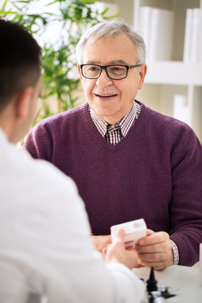 Medical doctor consulting senior patient