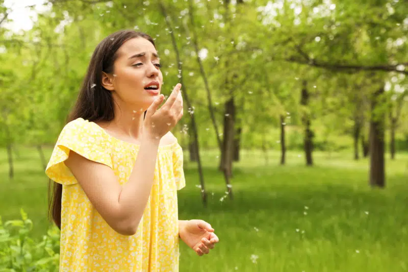 Young woman outdoors suffering from pollen allergies