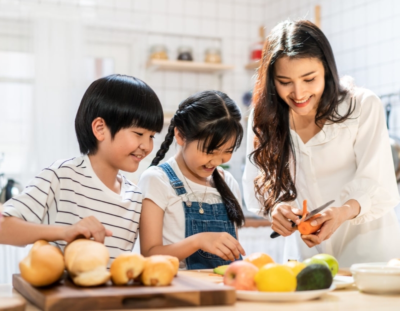 Children and mother preparing fruits and vegetables to avoid oral allergy syndrome symptoms naturally.
