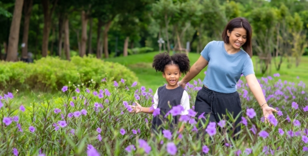 Mother and daughter walking through a field of flowers