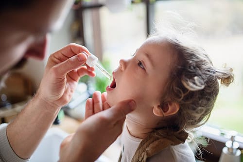 Kid getting allergy drops in AllerVie Health center