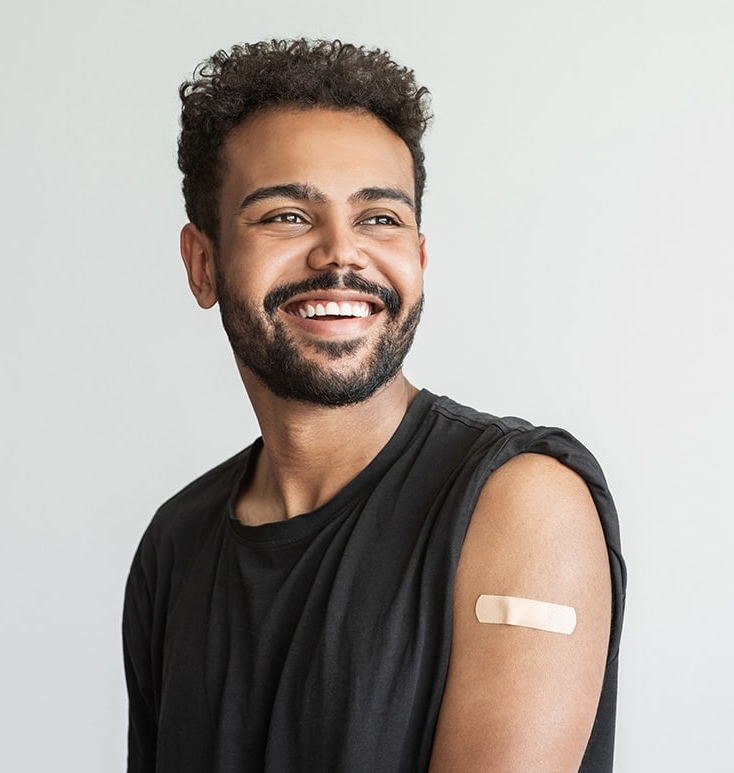 Smiling man with a band-aid on his left arm from an allergy shot
