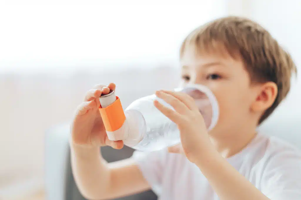 Child using an asthma inhaler 
