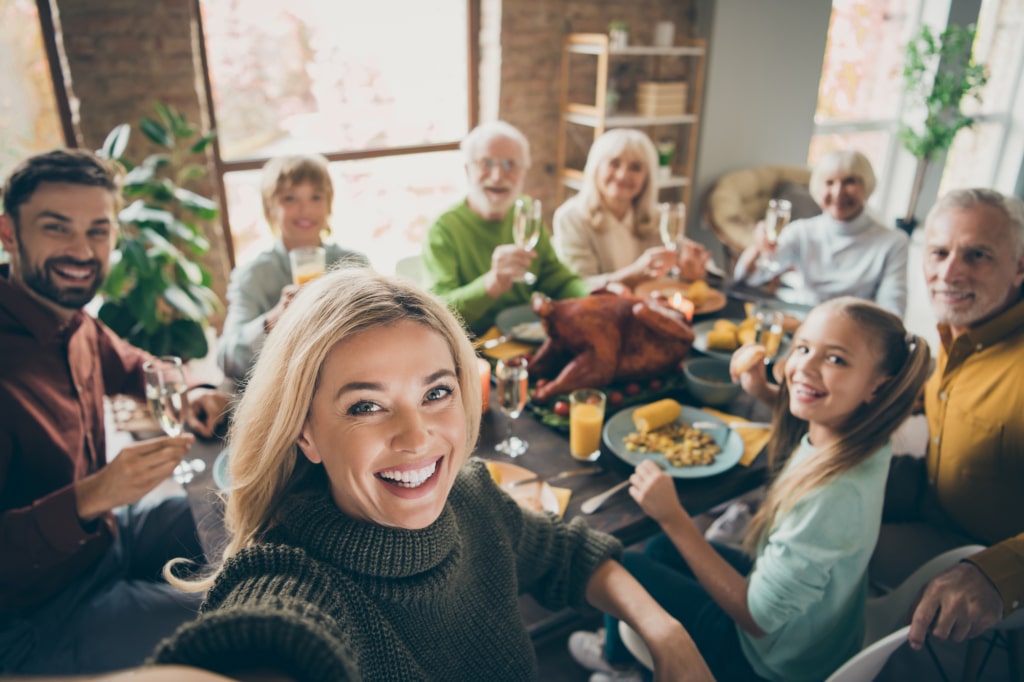 Family and friends of all ages and genders having dinner and celebrating a special occasion