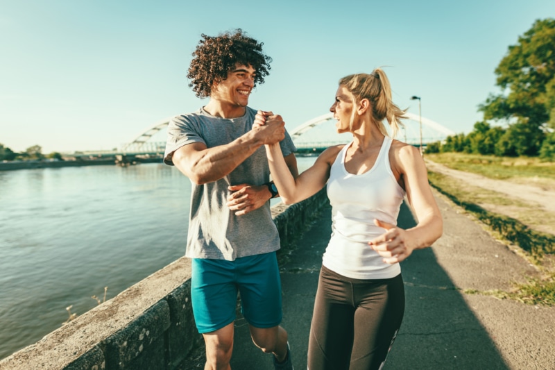 Couple running through the city with no asthma or beathing issues.