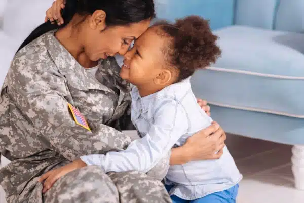 Military mother and daughter with both their foreheads pressed together and hugging