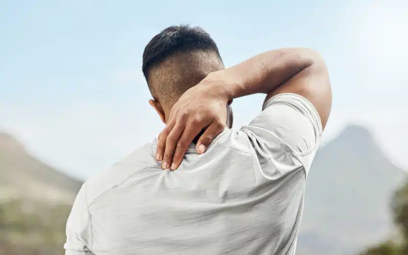 Man scratching his back while on a run due to hives