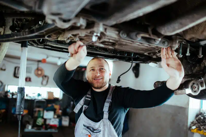 Young man working on a car, mechanics are exposed to elements that can cause occupational asthma