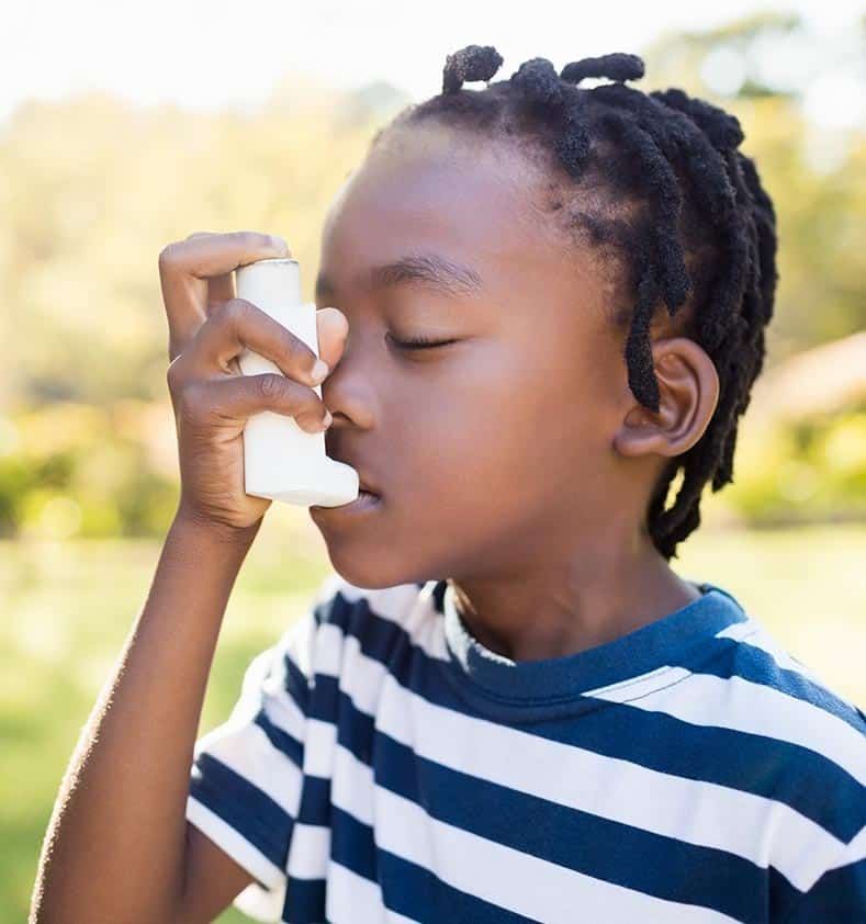 Kid with severe asthma using an asthma inhaler at the park